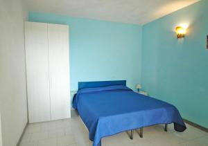 a blue bedroom with a bed and a white cabinet at Arlecchino in Capoliveri