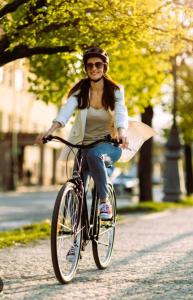 a woman riding a bike down a street at Chez l'ahumat in Aire-sur-lʼAdour