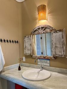 La salle de bains est pourvue d'un lavabo et d'une fenêtre. dans l'établissement Pousada Casa Mucugê, à Porto Seguro