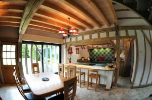 eine Küche mit einer Holzdecke und einem Tisch in der Unterkunft Le pic drille in Charmont-sous-Barbuise