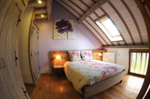 ein Schlafzimmer mit einem großen Bett im Dachgeschoss in der Unterkunft Le pic drille in Charmont-sous-Barbuise