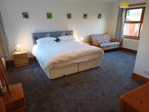 a bedroom with a large bed and a chair at North Blairkip Eildon in Sorn