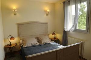 ein Bett in einem Schlafzimmer mit zwei Lampen und einem Fenster in der Unterkunft Le four banal in Bligny