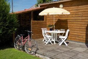 Bouy-LuxembourgにあるLe nid d'hirondellesのウッドデッキ(テーブル、自転車2台、傘付)