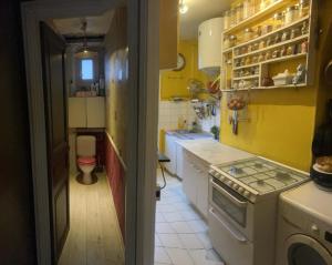 圣旺Chambre en appartement - Proche métro 13 et 14的黄色的厨房设有水槽和卫生间