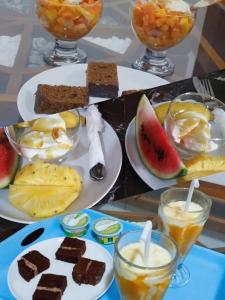 a table topped with plates of food with desserts and drinks at Brave resort Mirissa in Mirissa