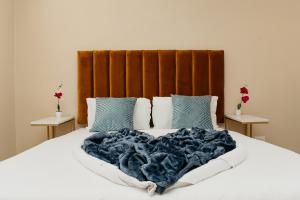 a large bed with a blue blanket and pillows at The City Club On Plein in Cape Town