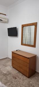 um armário de madeira num quarto com um espelho em Be Our Guest em Lepanto