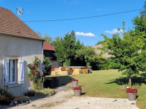 un patio con una casa y un patio con plantas en Chez la francine en Noë-les-Mallets