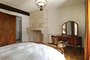 Schlafzimmer mit einem Bett, einer Kommode und einem Spiegel in der Unterkunft Les perrieres in Les Riceys