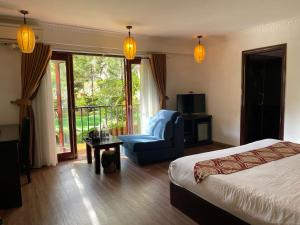 a bedroom with a bed and a chair and a balcony at Sapa Elite Hotel in Sa Pa