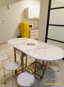 stół i cztery stołki w kuchni w obiekcie JQ Citypads by Golden Stay w mieście Kota Kinabalu