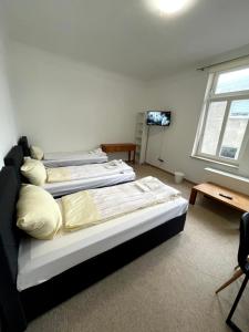 a room with two beds and a television in it at Monteurwohnung am Holstein-Center in Itzehoe