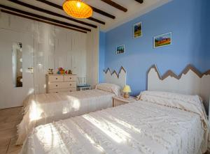 2 Betten in einem Schlafzimmer mit blauen Wänden in der Unterkunft Les colchiques in Racines