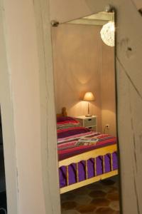 1 dormitorio con 1 cama con espejo en Les rosiers, en Onjon