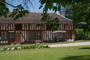 Onjon的住宿－Les rosiers，庭院内带门廊和桌子的房子