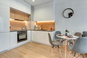 a kitchen and dining room with a table and chairs at Comfort Apartments Kopernika in Gdynia