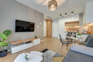 un salon avec une télévision et une salle à manger dans l'établissement Comfort Apartments Kopernika, à Gdynia