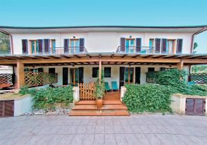 a large white house with a porch and a patio at L' Oleandro in Marina di Campo