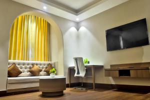 a living room with a couch and a television at Hotel Kant Palace in Tājganj +23 photos