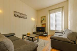 a living room with two couches and a television at L'alnilia in Romilly-sur-Seine