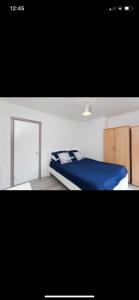 a bedroom with a blue bed and a mirror at House @ Queens University in Belfast