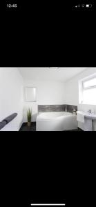 a bathroom with a white bed and a sink at House @ Queens University in Belfast