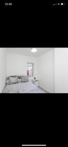 ein weißes Schlafzimmer mit einem Bett und einem Fenster in der Unterkunft House @ Queens University in Belfast