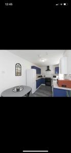 a kitchen with blue and white cabinets and a table at House @ Queens University in Belfast