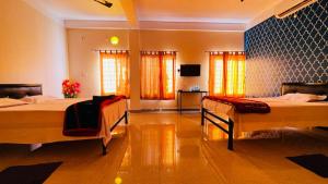 1 dormitorio con 2 camas y TV. en Nilachal Homes en Guwahati