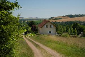 un camino de tierra que conduce a una casa en una colina en Les bigarreaux, en Paisy-Cosdon
