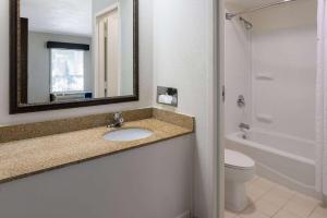 een badkamer met een wastafel, een toilet en een spiegel bij Studio 6 Suites Jacksonville, NC in Jacksonville +47 foto's