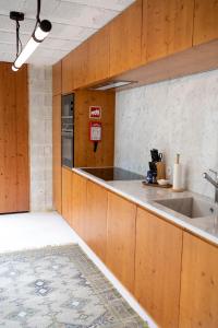 eine Küche mit Holzschränken und einem Waschbecken in der Unterkunft Fisherman's Blues - Casa na Praia in Arcozelo