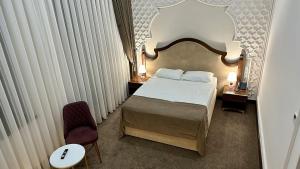 a hotel room with a bed and a chair at Reikartz Sote Tashkent in Tashkent