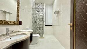a bathroom with a toilet and a sink and a shower at Reikartz Sote Tashkent in Tashkent