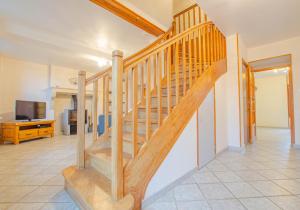 - un escalier en bois dans un salon avec une télévision dans l'établissement Le gite de la boderonne, à Villy-en-Trodes