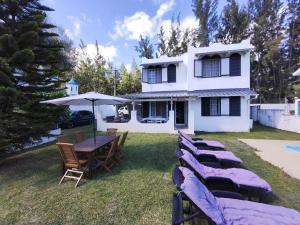 a group of chairs and a table in front of a house at Wonderful beach bungalow in the south. in Riambel