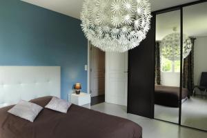a bedroom with a bed and a chandelier at Gîte 10G34 in Ville-sur-Arce