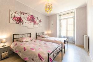 1 dormitorio con 2 camas y lámpara de araña en Le gite de tatanne en Villenauxe