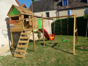 een houten speeltuin met een ladder en een schommel bij Le gite de tatanne in Villenauxe-la-Grande