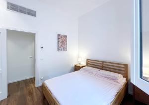 a white bedroom with a bed and a window at Solemar Sicilia - Palazzo Pirrotta in Palermo