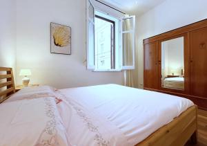 a bedroom with a large white bed with a window at Palermo Blu - Palazzo Pirrotta in Palermo