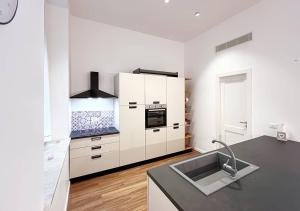 a kitchen with white cabinets and a stainless steel sink at Solemar Sicilia - Palazzo Pirrotta in Palermo +53 photos