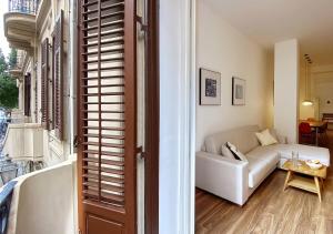 a living room with a white couch and a table at Solemar Sicilia - Palazzo Pirrotta in Palermo