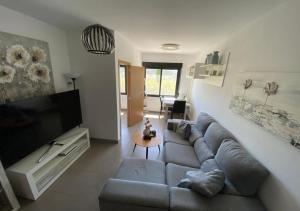sala de estar con sofá y TV de pantalla plana en Near Moraira Apartment in Benitachell 2, en Benitachell