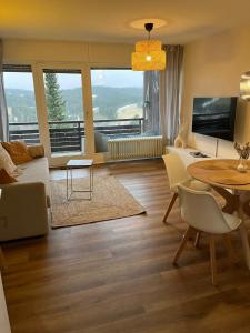 a living room with a table and a dining room at BLACKFOREST LOFT - Panoramablick Schwarzwald in Schonach