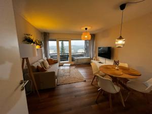 a living room with a table and chairs and a living room at BLACKFOREST LOFT - Panoramablick Schwarzwald in Schonach