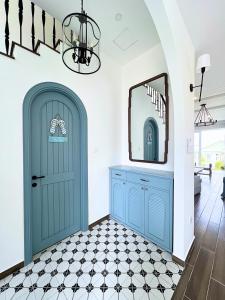 a hallway with a blue door and a mirror at Seamoni Seaview Villa 02 - Novaworld Phan Thiết in Phan Thiet