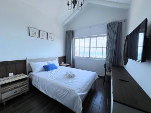 1 dormitorio con 1 cama y TV en Seamoni Seaview Villa 02 - Novaworld Phan Thiết en Phan Thiet