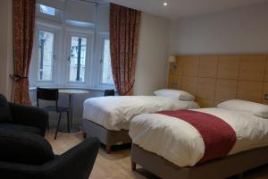 Pokój hotelowy z 2 łóżkami i krzesłem w obiekcie The Alma Rooms w Londynie